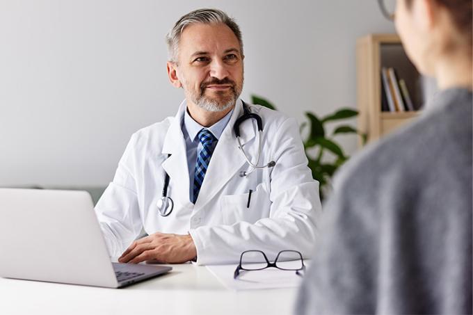 Gelukkige arts luistert naar patiënt