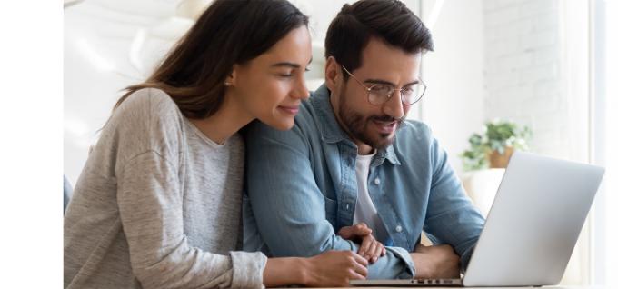 Jong koppel achter laptop als inspiratiebeeld op pagina over huurwaarborg op geblokkeerde rekening