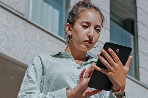 Young arab businesswoman portrait checking his work at the tablet net book outdoors office serious contrasting information and data online. Financial investment and crypto concept