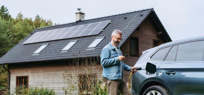 Man staat voor huis met zonnepanelen
